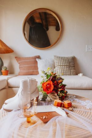 Cozy living room with white sofa, decorative pillows, and orange floral centerpiece.