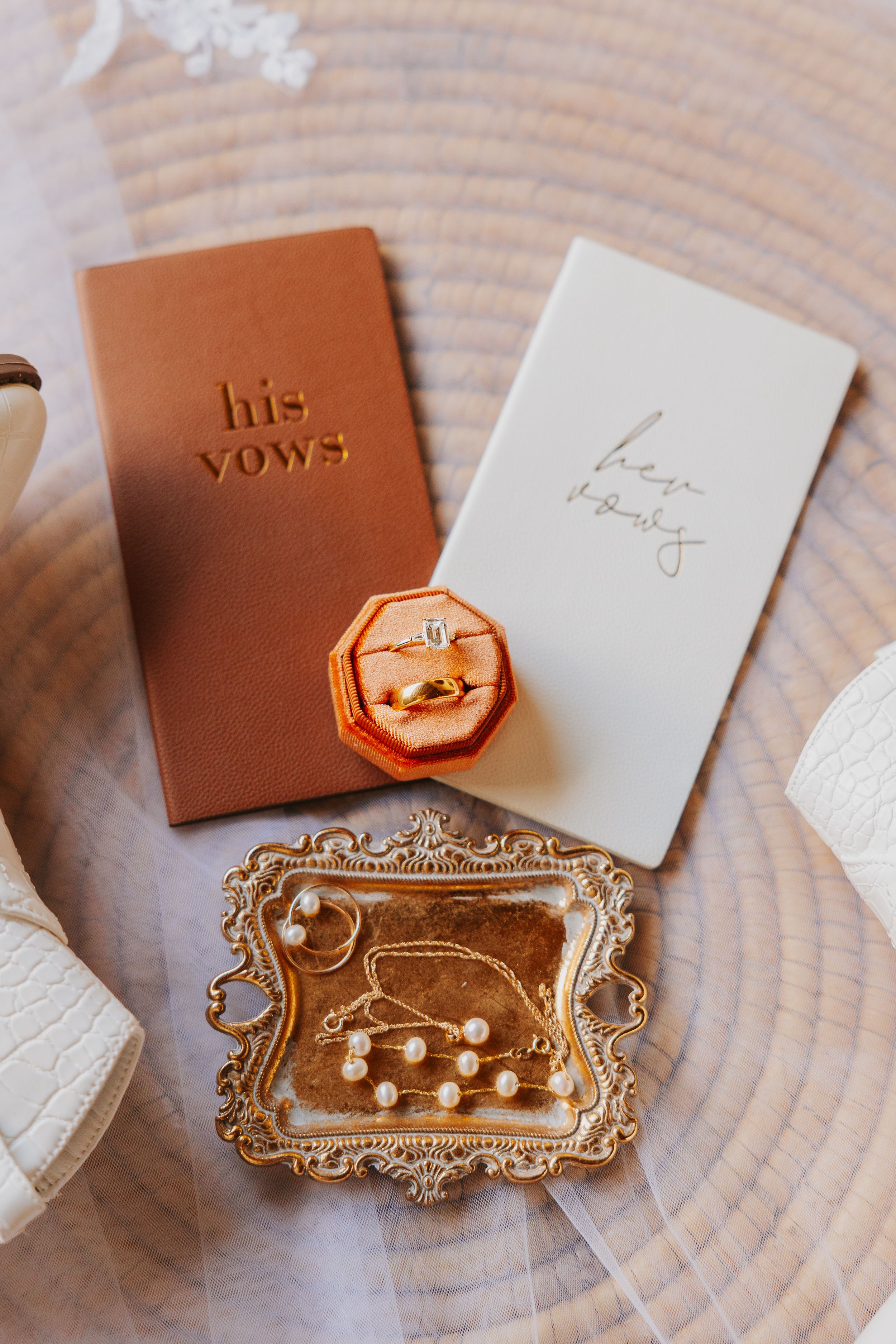 Elegant wedding vow books with gold wax seals and vintage trays on wooden background.
