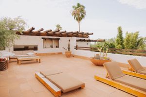 Spacious outdoor terrace with wooden furniture and desert landscape views.