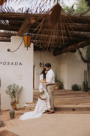 Desert wedding venue with rustic wooden ceiling and adobe walls featuring Posada signage.