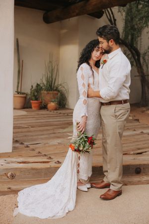 Romantic wedding photos taken under covered patio with terracotta tiles and desert landscaping.