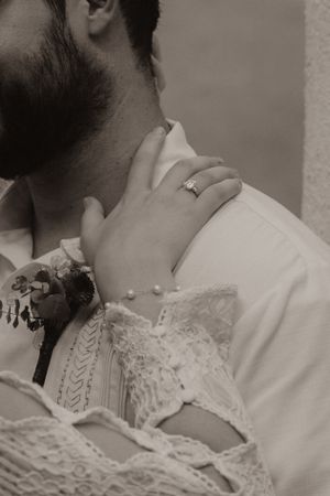 Close-up black and white shot of couple in intimate embrace wearing wedding attire.