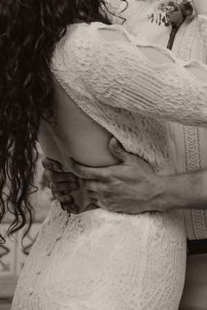 Intimate black and white photos of couple embracing in lace wedding dress.