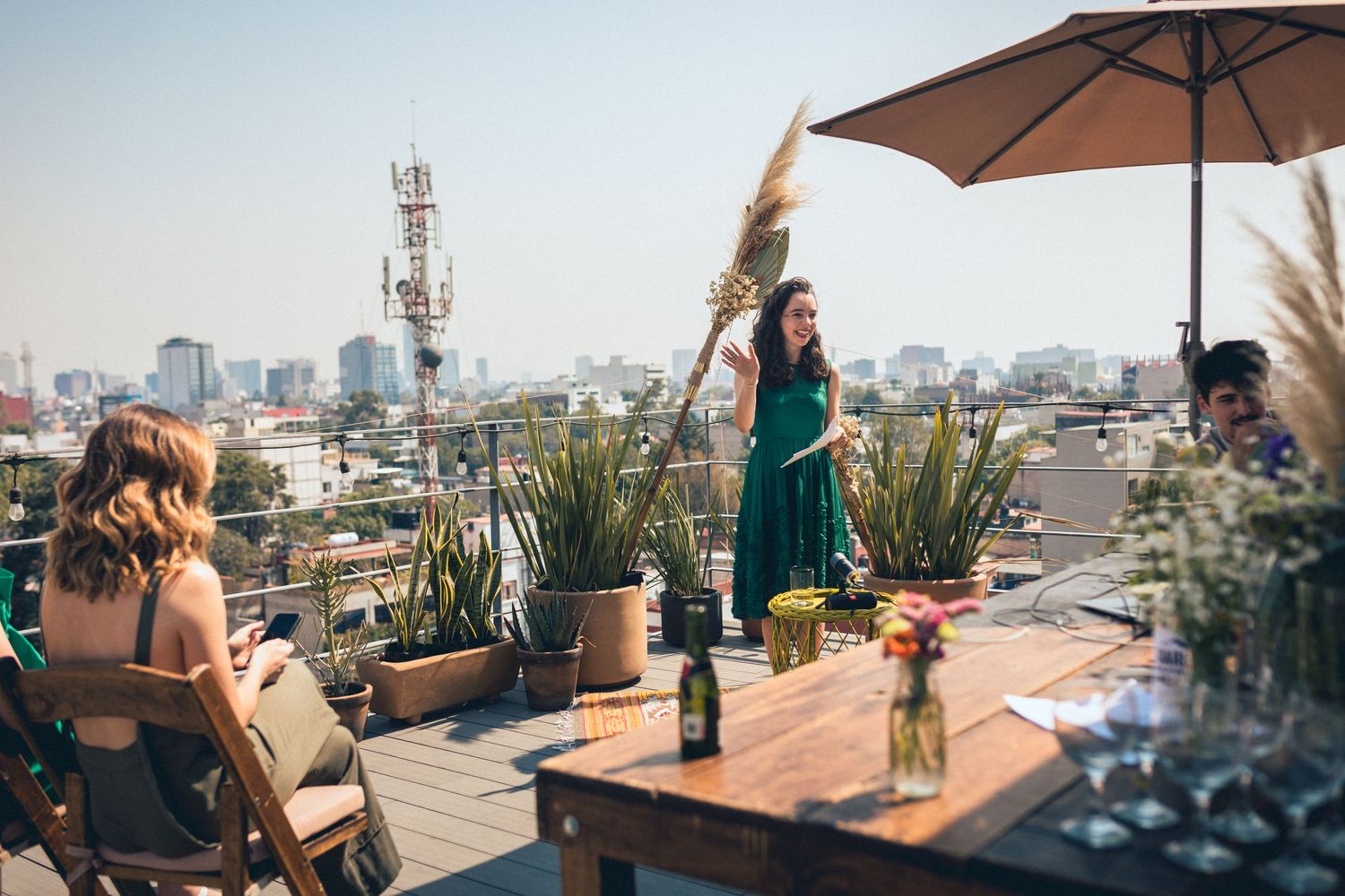 Rooftop terrace setup with umbrella and furniture overlooking city landscape.