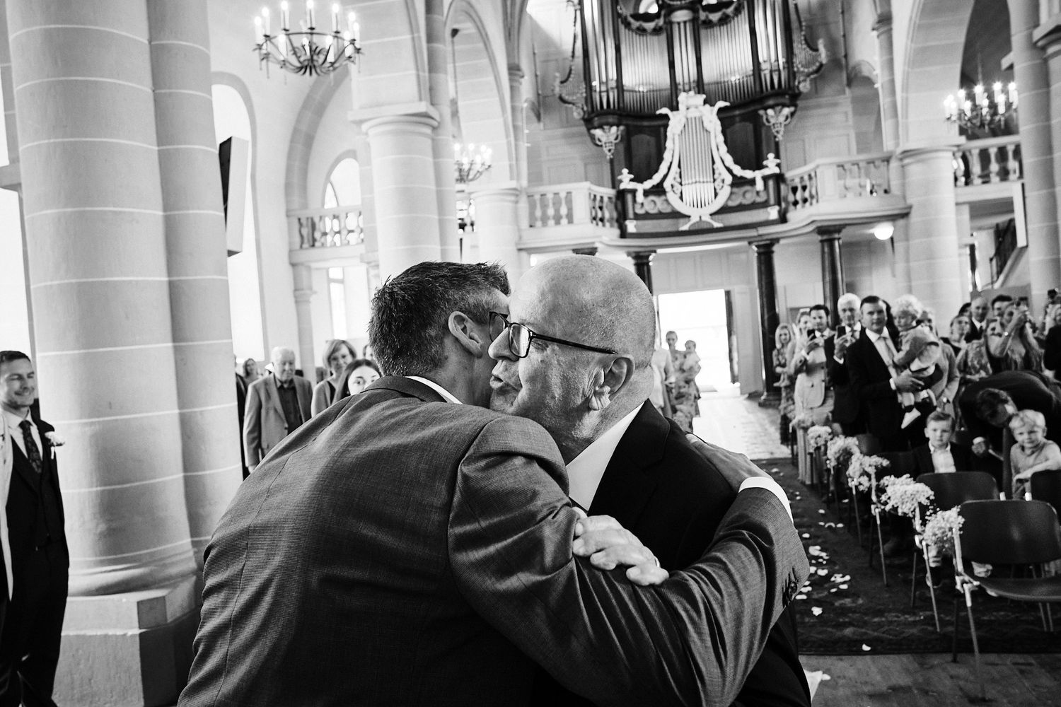 TLOOK photographe de mariage de style documentaire, cérémonie à l'église le papa embrasse le marié