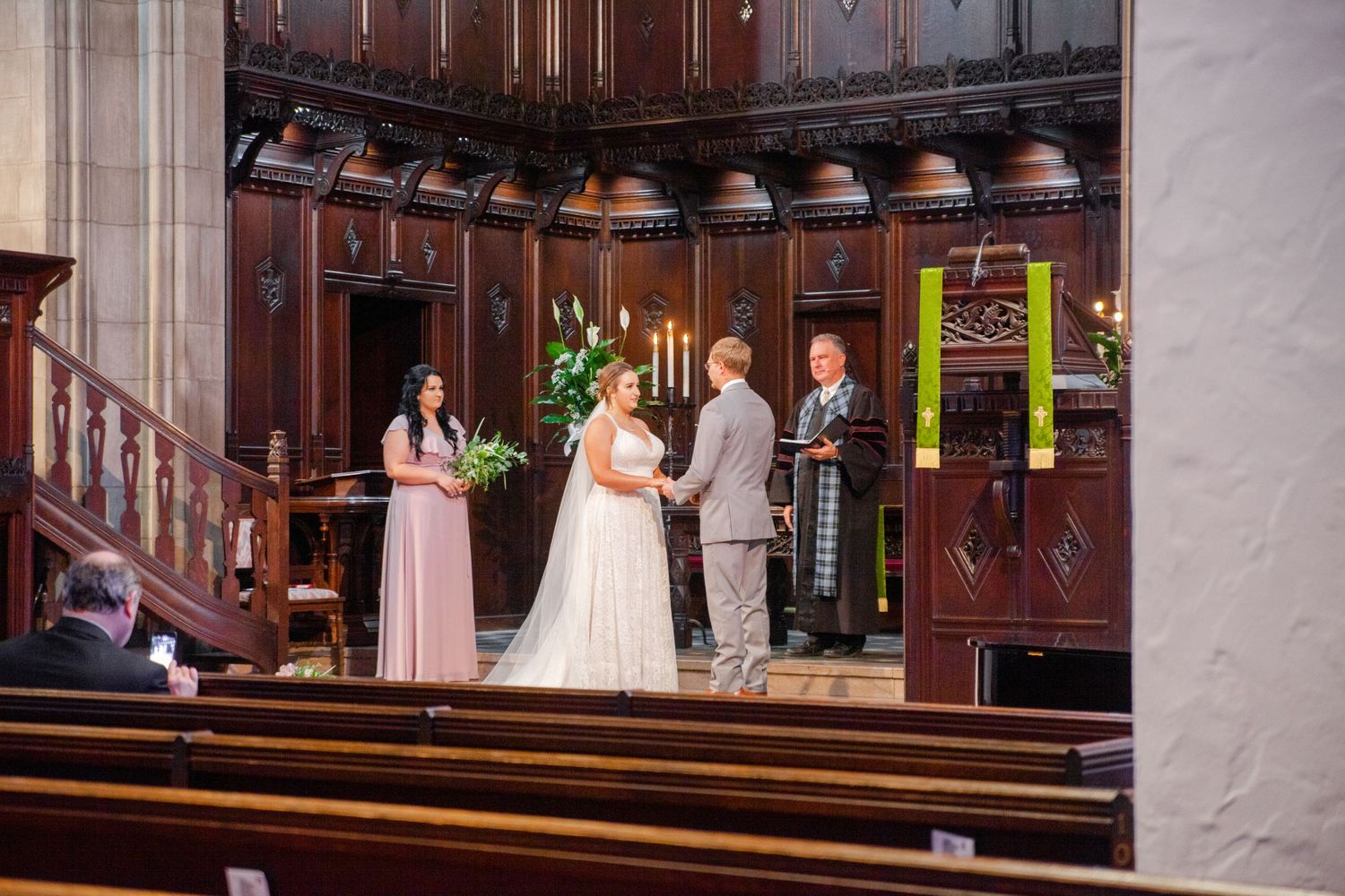 Church sanctuary with ornate wooden details and decorative elements during a wedding ceremony.