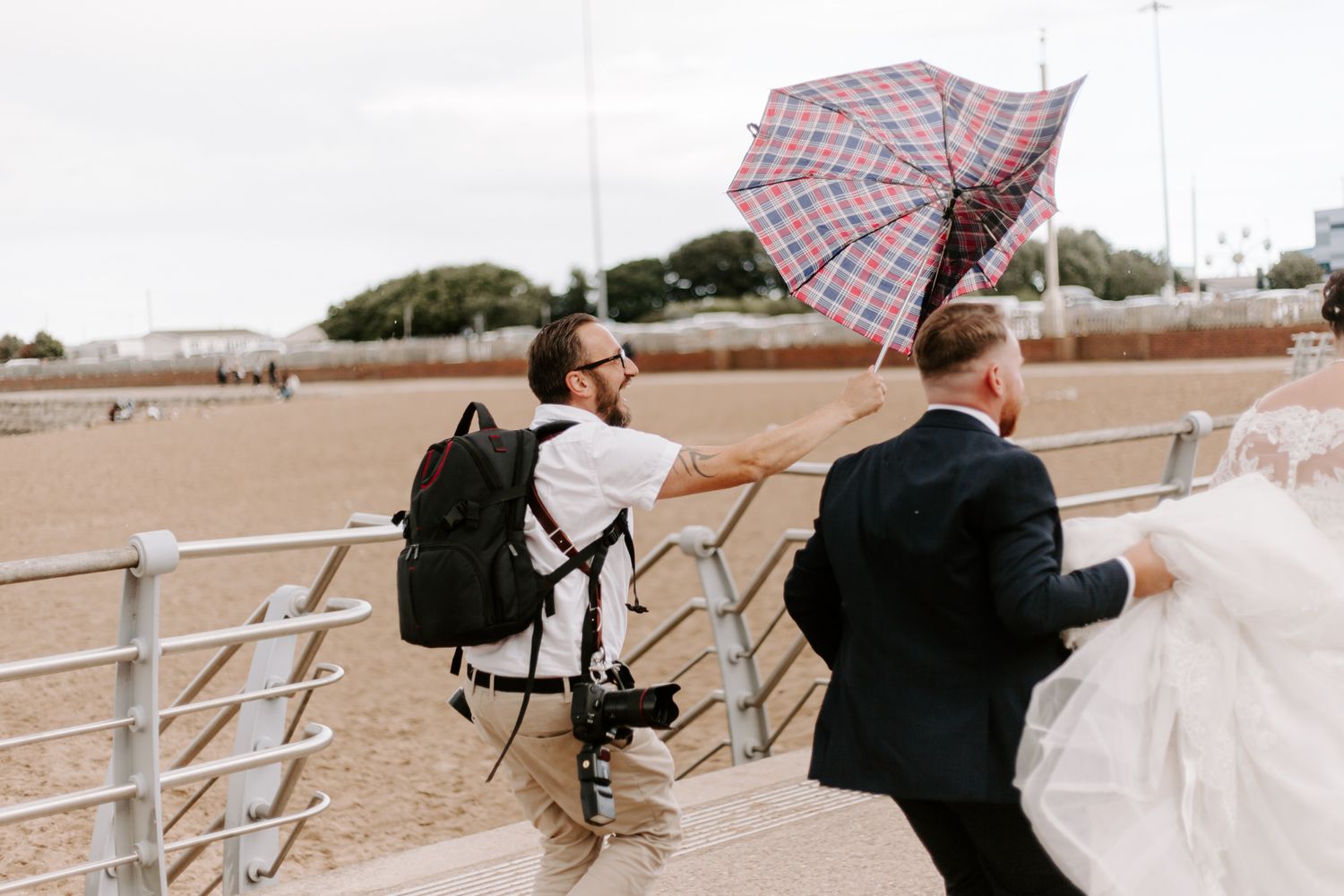 photographer holding brolly for the bride