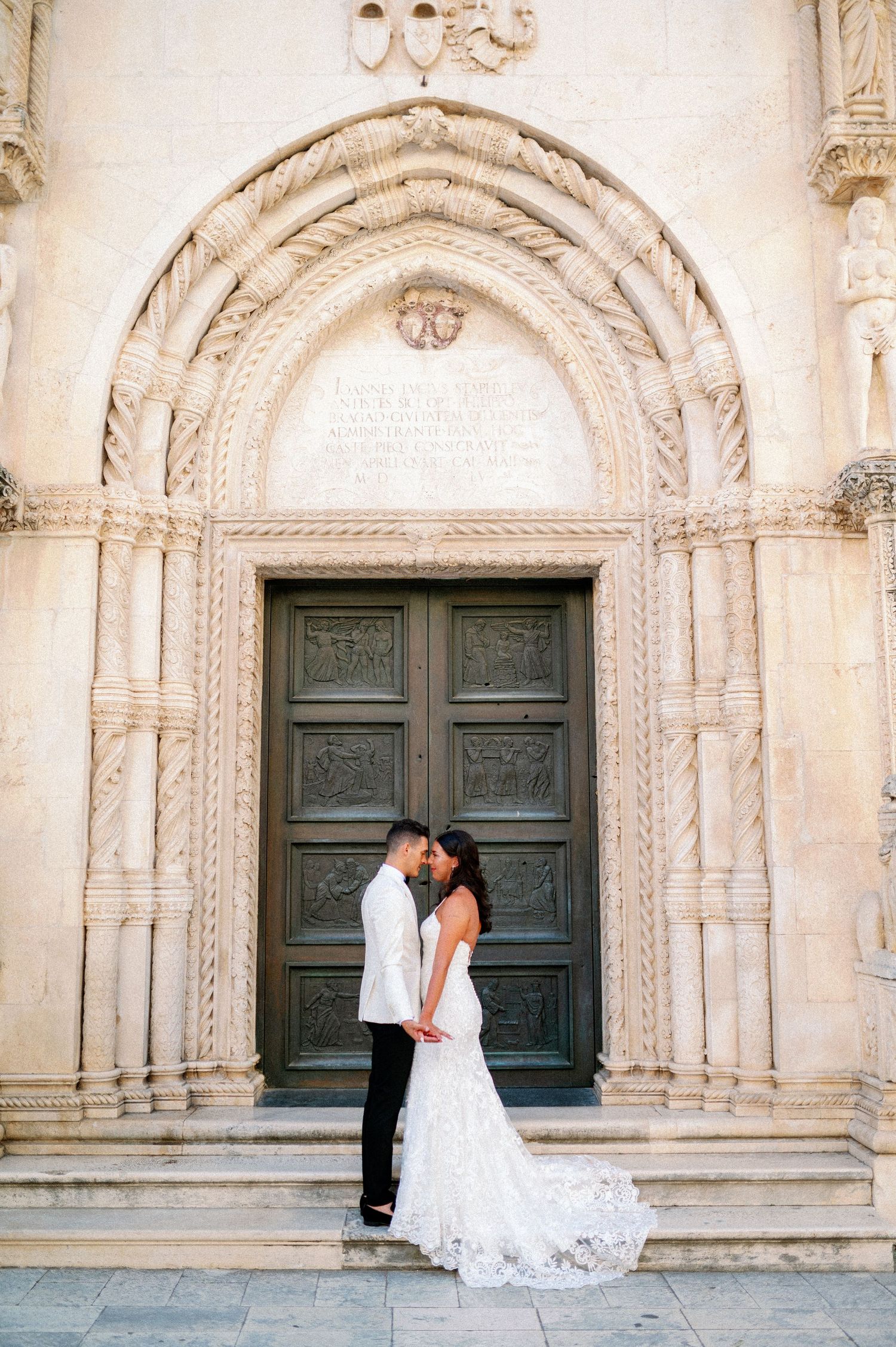 Beautiful historic cathedral entrance with ornate stone archway and carved wooden doors creating an elegant backdrop.