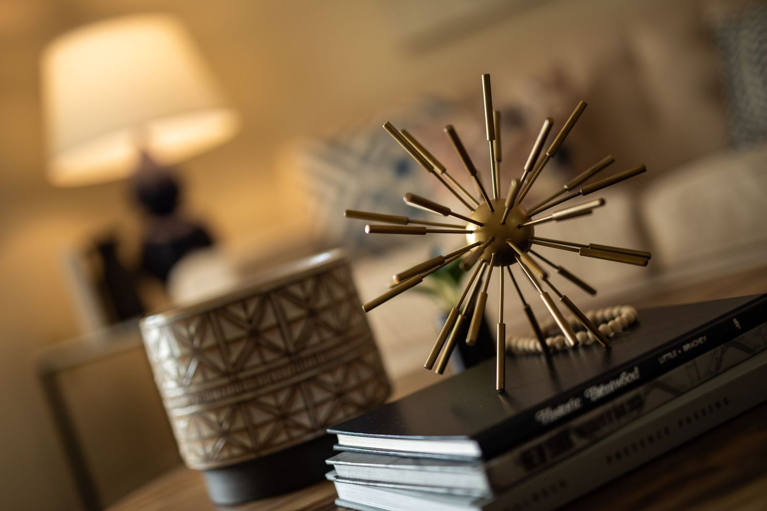 Modern starburst decorative object displayed on stacked books with soft ambient lighting.