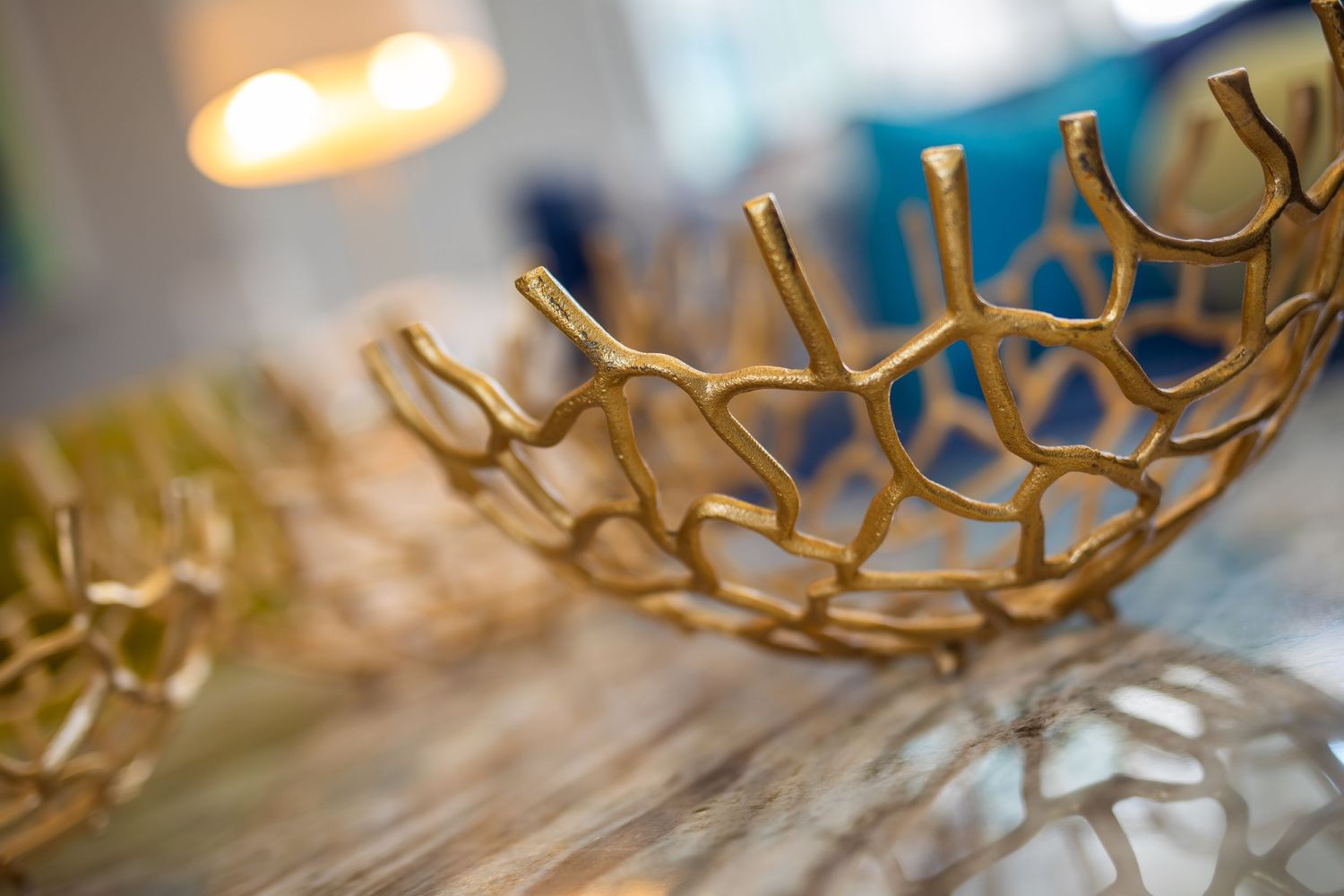 Close-up detail of a decorative gold wire bowl with intricate geometric patterns.