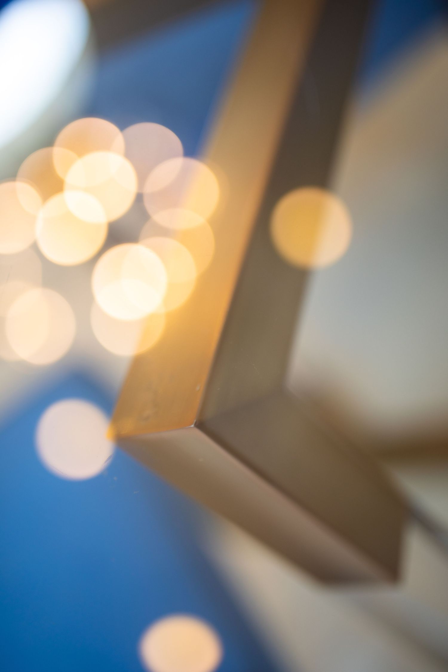 Abstract soft focus photograph with warm bokeh lights against a blue background.
