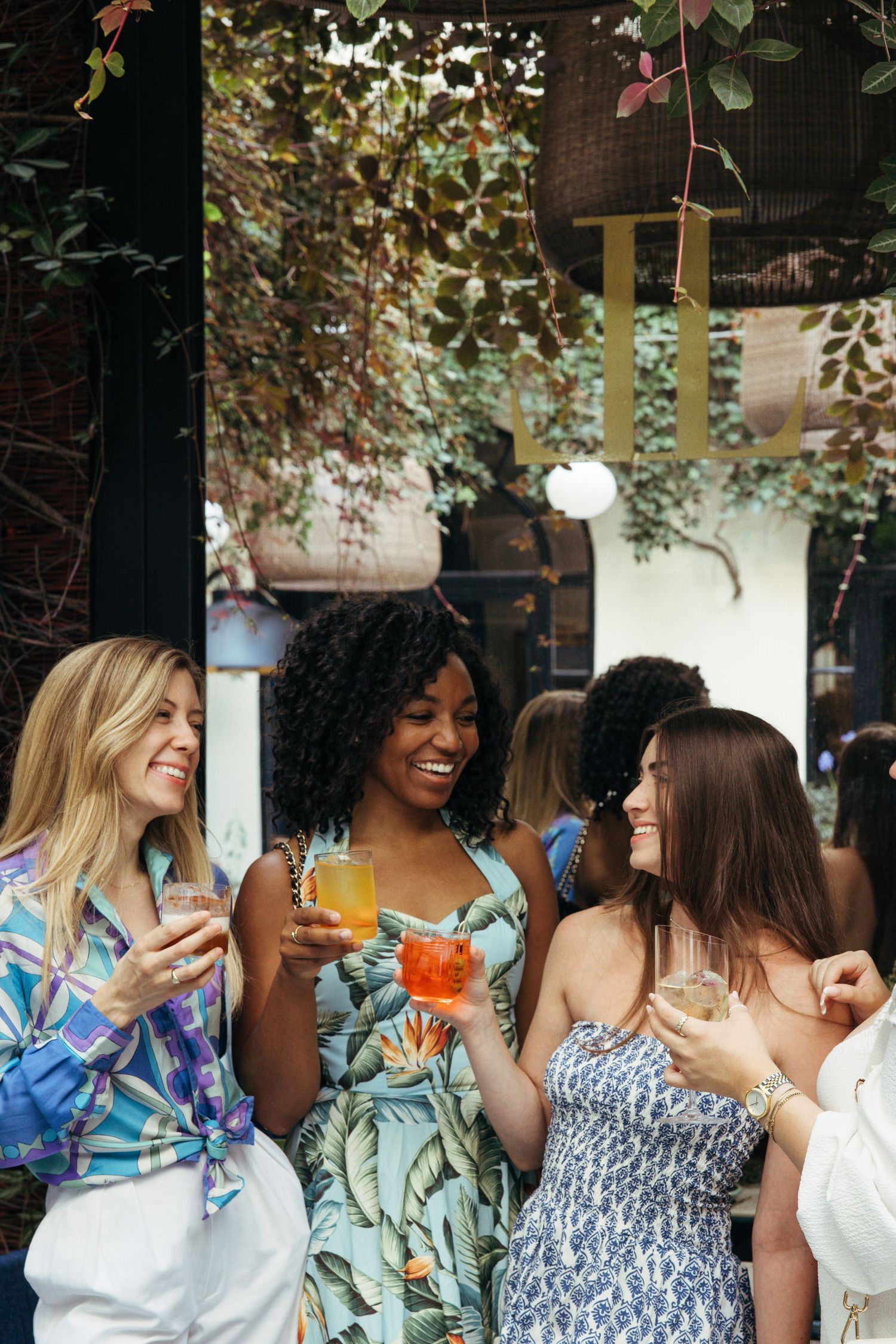 Group enjoying colorful cocktails at an outdoor patio gathering.