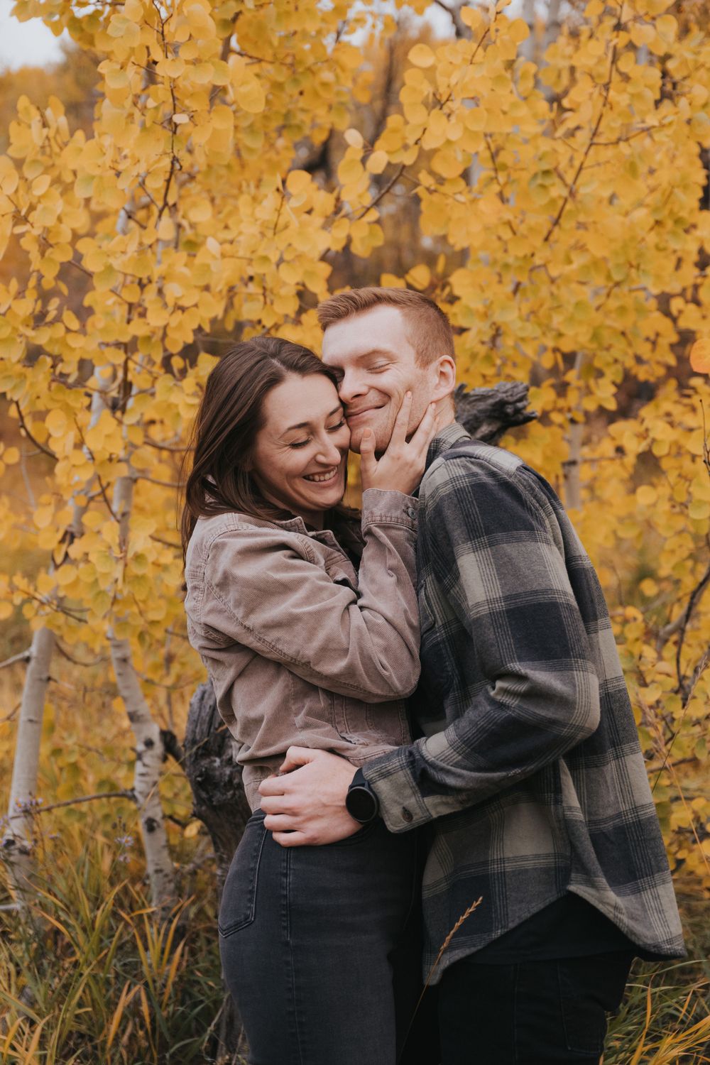 Engaged couple laughs during Utah fall engagement session, photographed by a Provo based photographer.