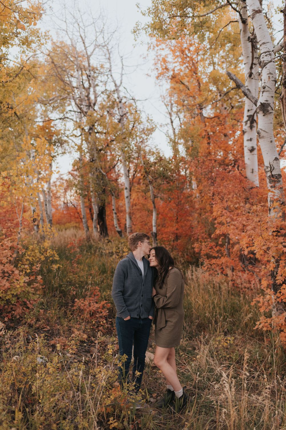A couple laughs during a fall engagement session, photographed by Park City wedding photographer.