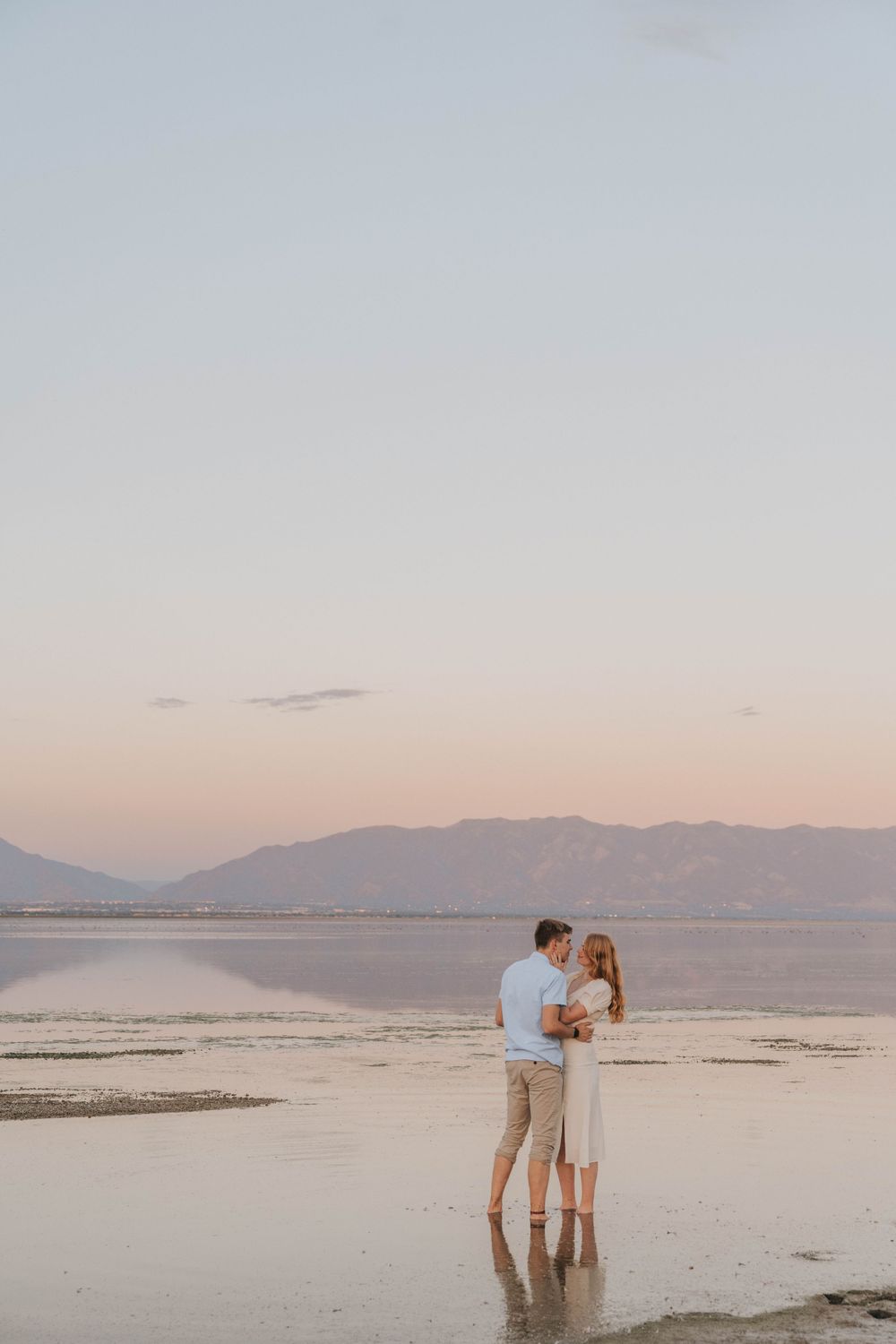 A couple embraces during a Utah engagement session near Antelope Island and the Great Salt Lake.
