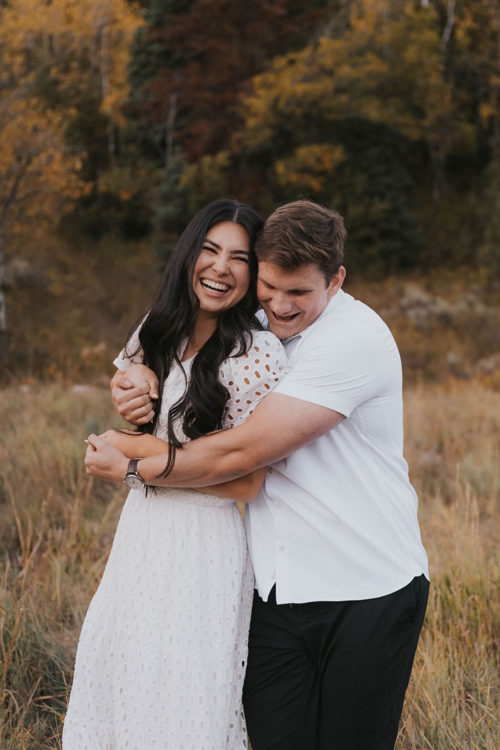 Engaged couple laughs during Utah fall engagement session, photographed by Utah Wedding Photographer