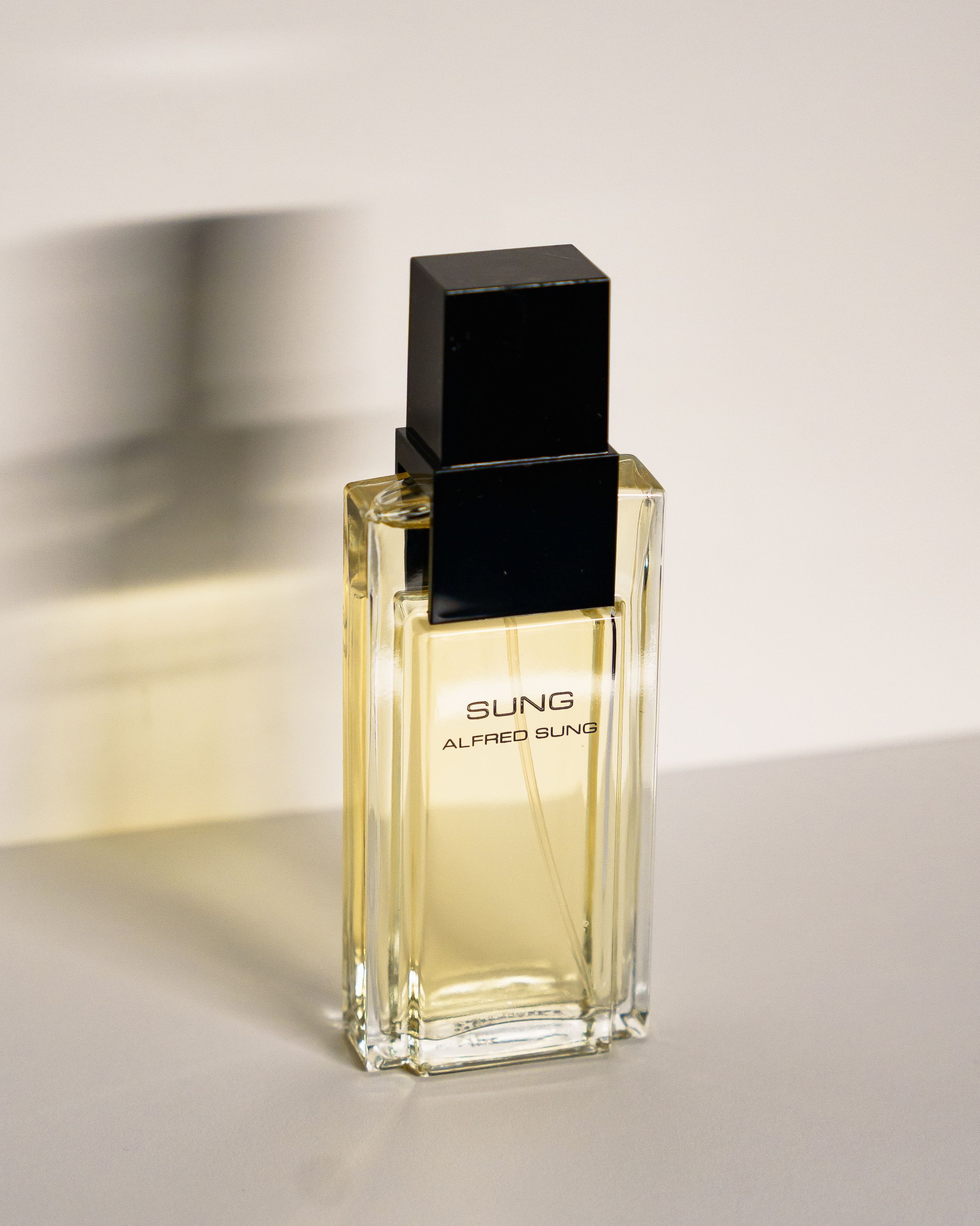 A luxurious perfume bottle labeled 'Sling' with clear liquid photographed in soft lighting.