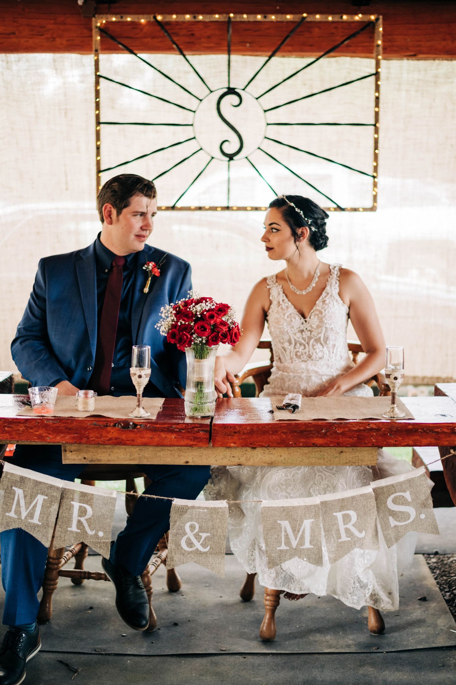 bride and groom holding hands at the head table at their wedding reception