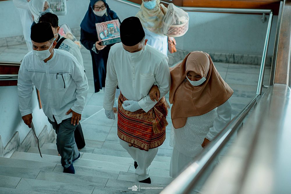 Group wearing traditional Islamic attire and masks ascending stairs.