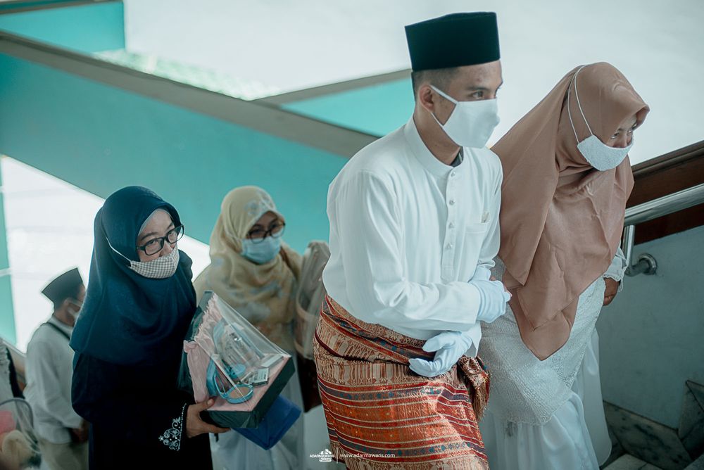 Group in traditional Muslim attire and face masks walking together.