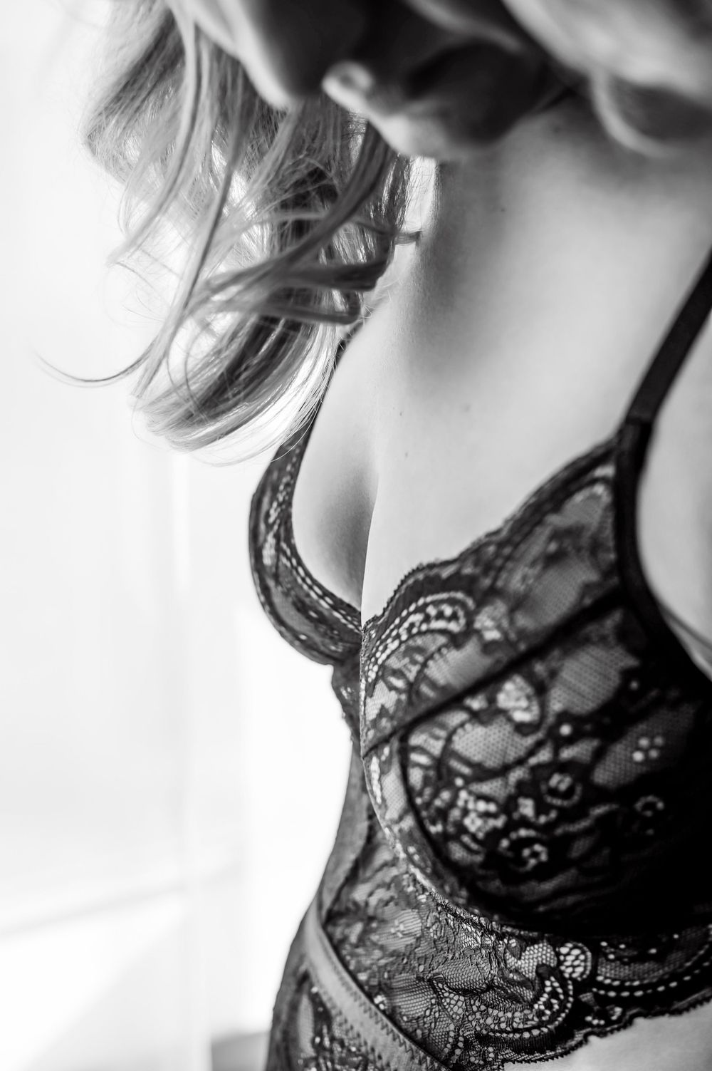 Beautiful boudoir portrait with soft lighting, highlighting the subject’s lingerie details and grace.