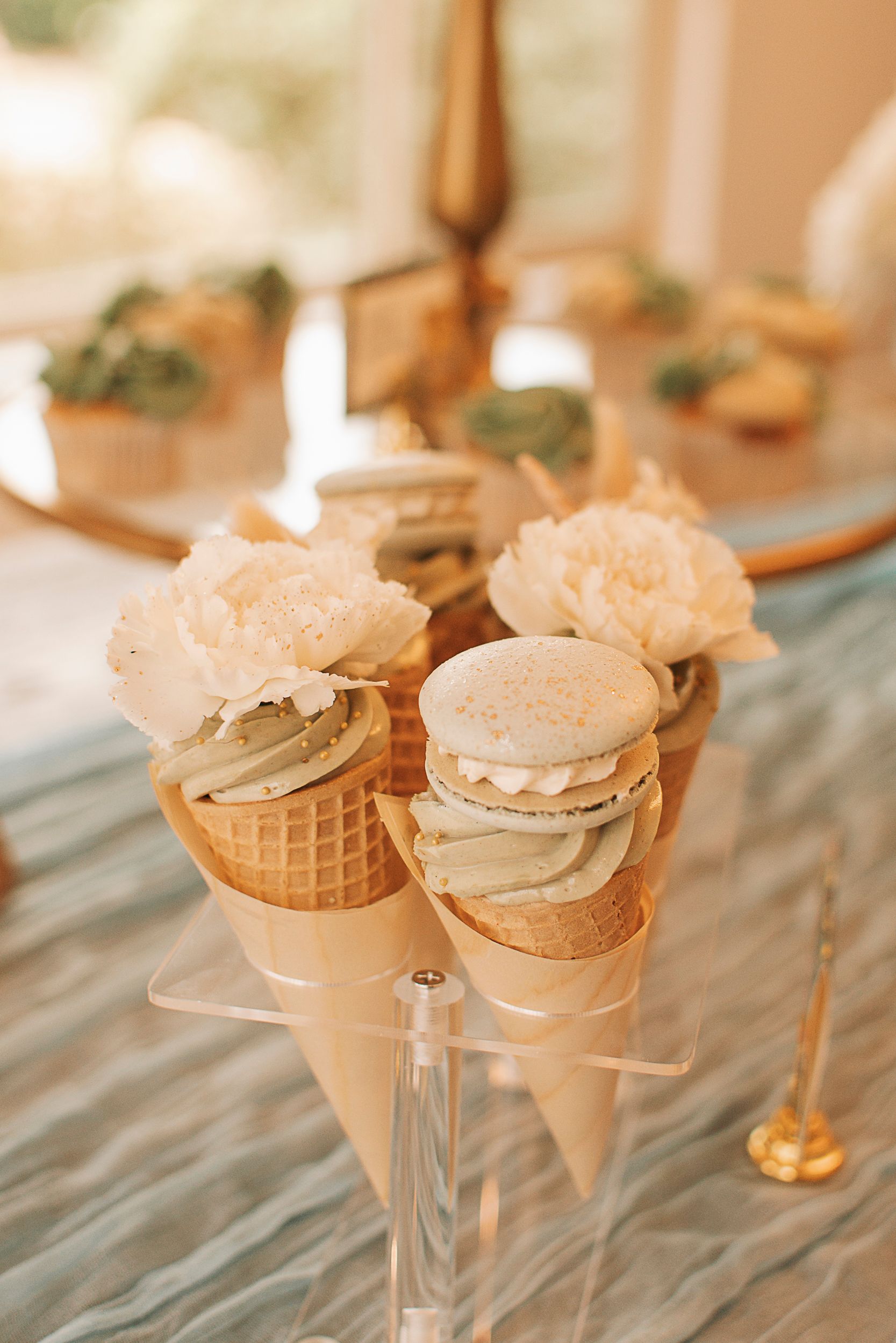 Ice cream cone party favors decorated with frosting and toppings on display.