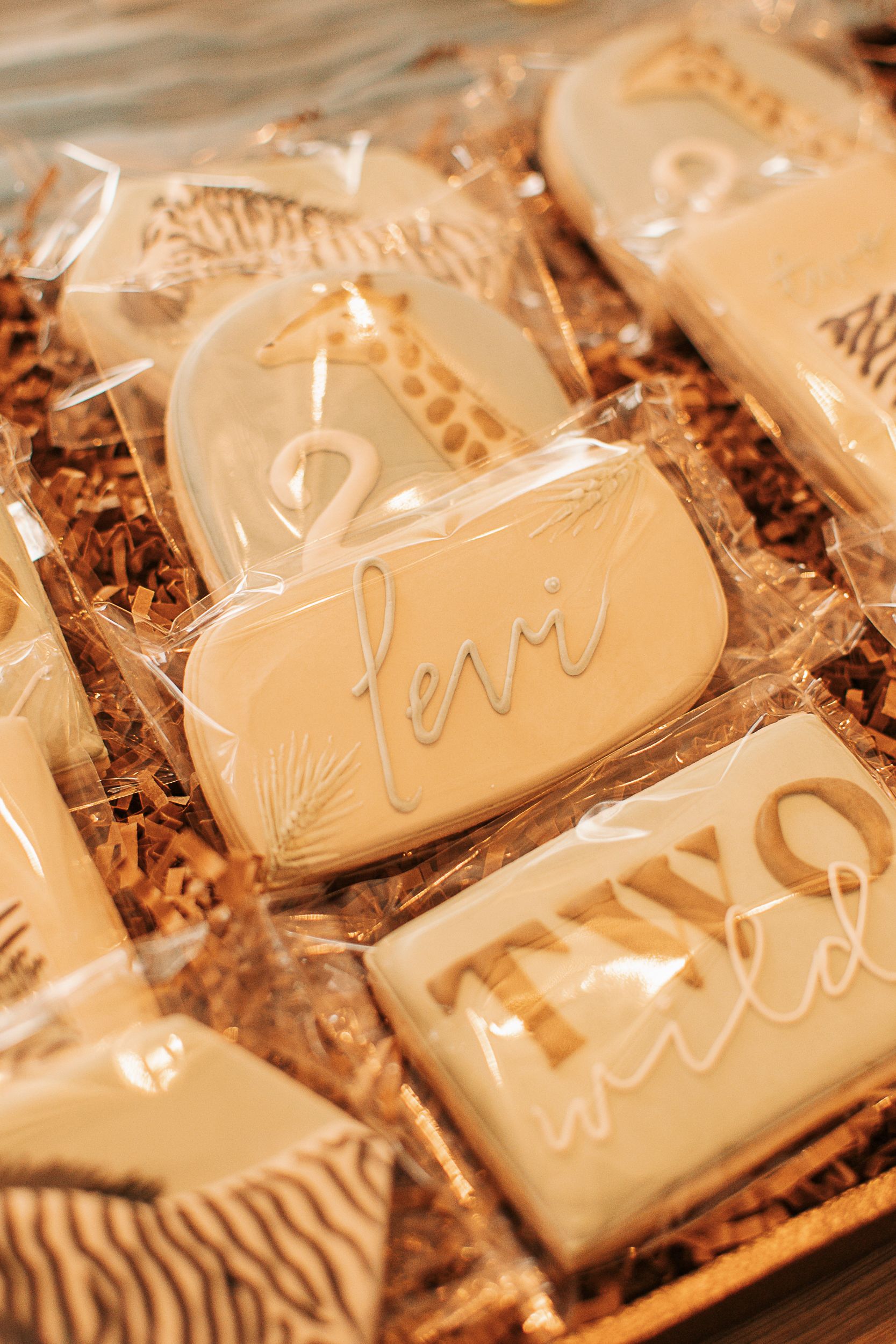 White frosted cookies with safari animal designs lined up on a table.