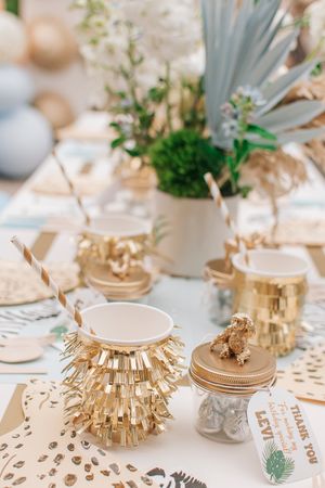 Elegant table setting with gold accents, striped placemats, and delicate floral centerpieces.