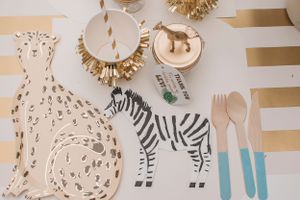 Safari-themed party decorations featuring zebra and giraffe patterns in neutral tones.