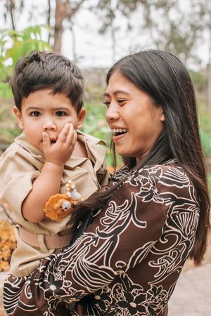 A candid moment outdoors showing shared laughter between two people in patterned clothing.