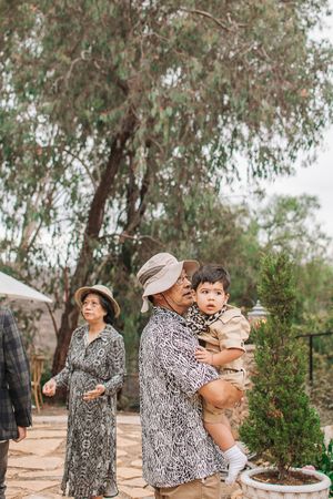 Outdoor safari party scene with eucalyptus trees and garden decor in background.