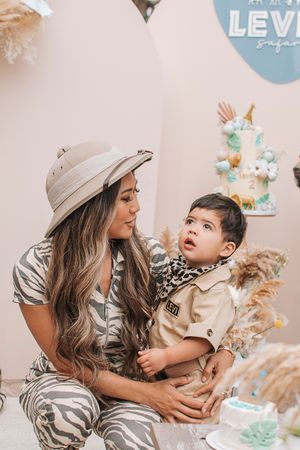 A family moment at a safari-themed celebration with decorative elements and balloons.