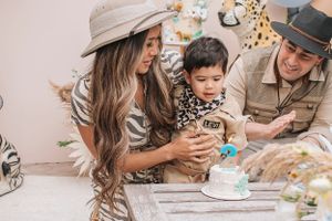An intimate family gathering at a safari-themed party with decorative backdrop.