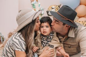 A family celebration moment at a safari-themed party with blue and beige decorations.