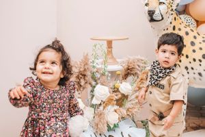 A family photo session with matching outfits including floral prints and safari-themed clothing.