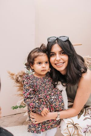 A tender moment captured during a family photoshoot with floral dress and neutral tones.
