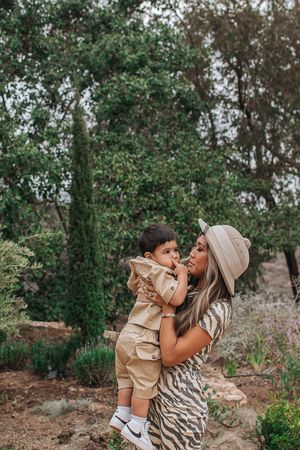 A playful outdoor photoshoot moment with matching safari-inspired outfits against a natural backdrop.