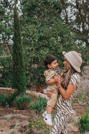 Candid family moments captured during an outdoor photography session with coordinated neutral outfits.