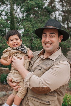 Playful outdoor family photos with safari-themed clothing and wide-brimmed hats.