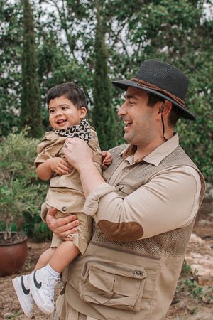 A heartwarming outdoor family portrait session with matching khaki outfits and safari-style hats.
