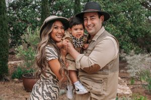 A happy family photo session outdoors featuring coordinated safari-inspired outfits and natural backdrop.
