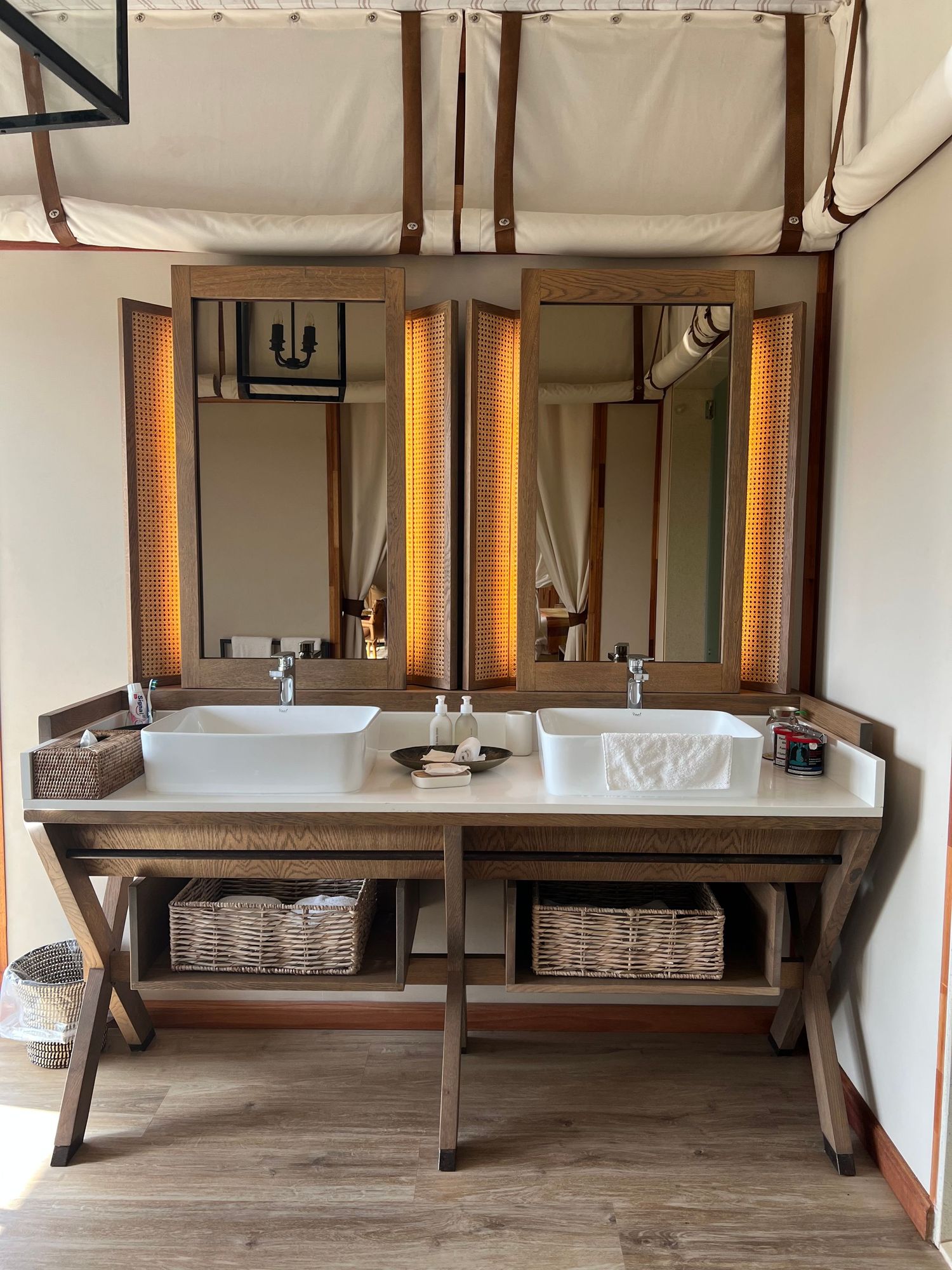 Rustic spa treatment room with wooden benches and white fabric drapes creating a serene atmosphere.