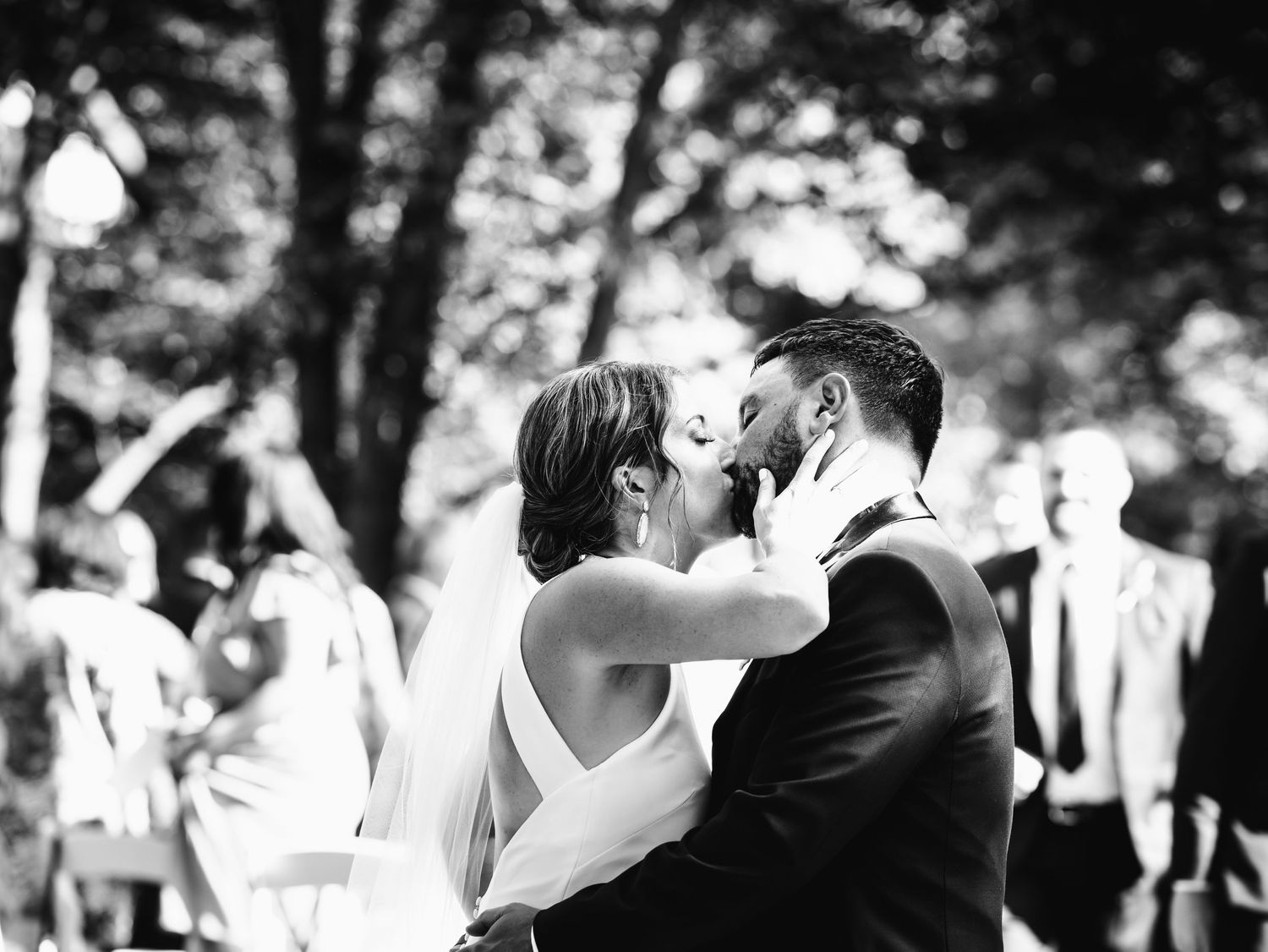 black and white photo of bride kissing groom