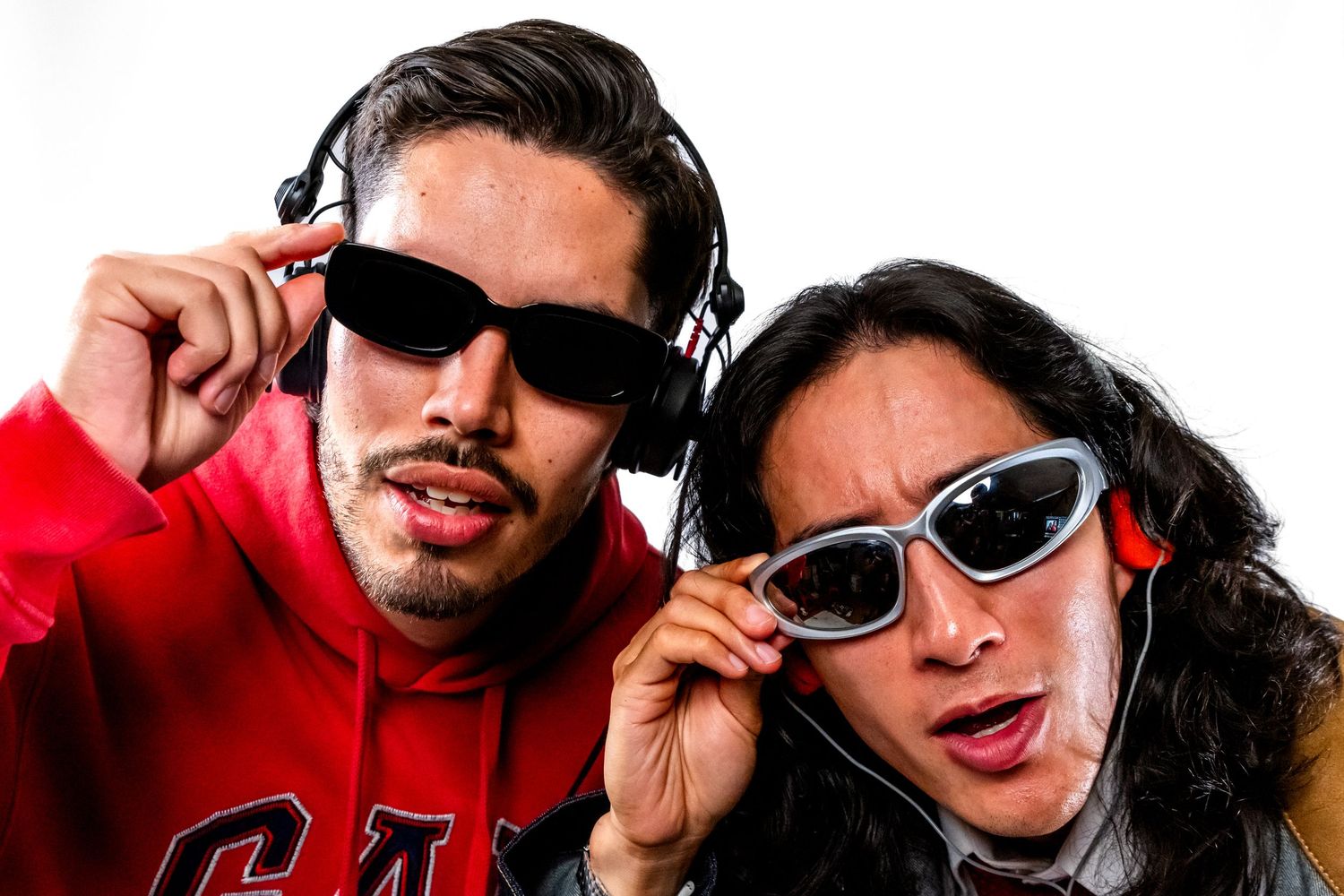 A close-up portrait studio photo of Can Nguyen and Dj Ario wearing sunglasses and headphones looking at the camera.