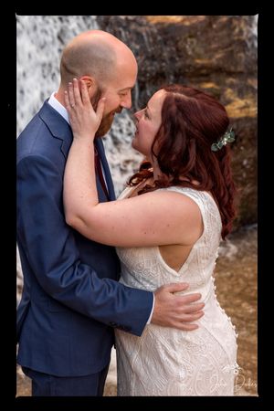 Intimate wedding couple portraits showing tender moments against stone background.