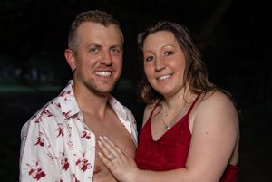 Engagement session at night with couple in red and floral outfits.