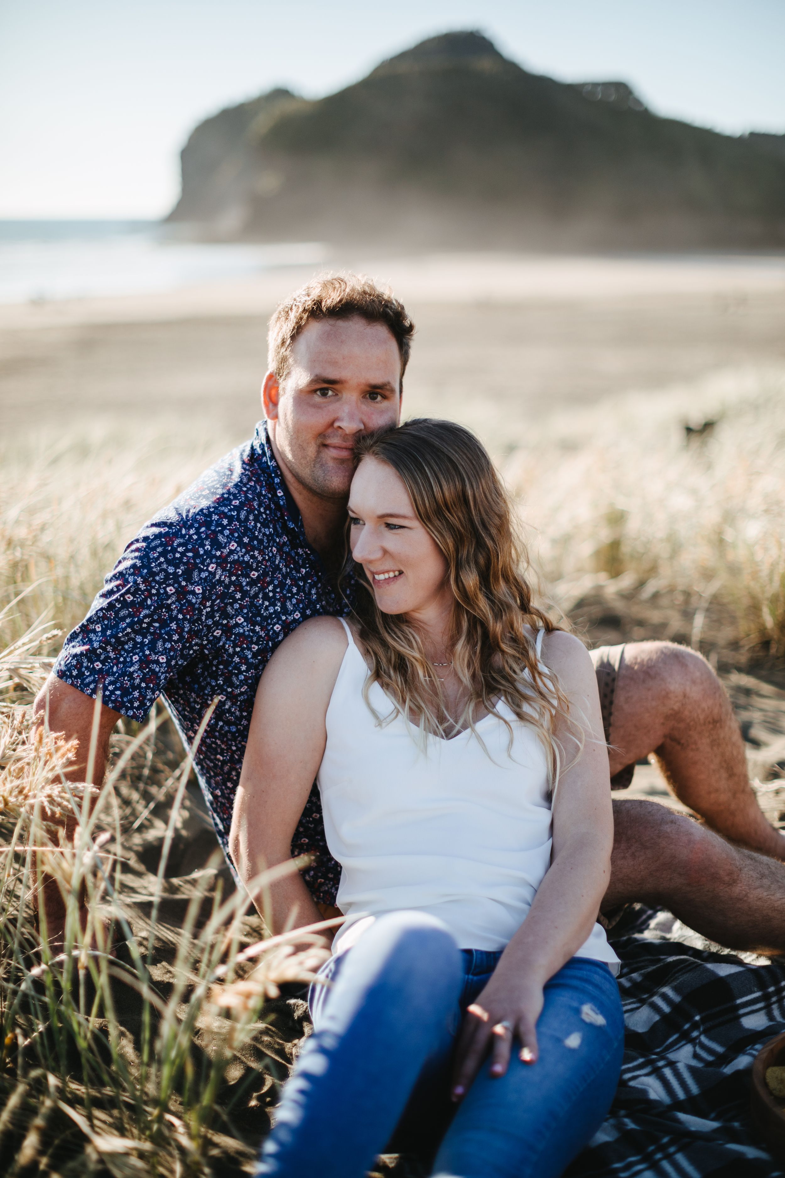 Couple posing on top of dunes at Bethells Beach, Kumeu Auckland