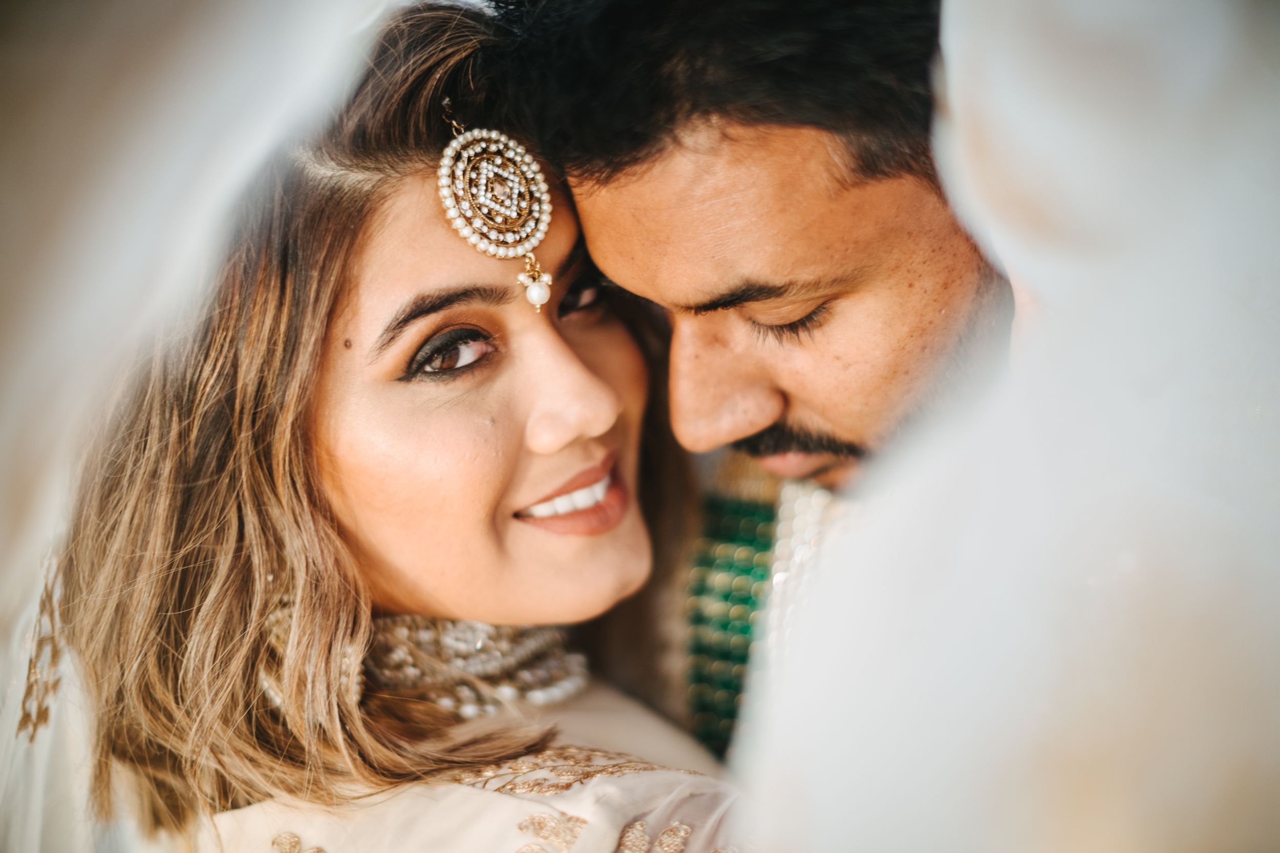 Indian couple posing under the veil at dunes in Muriwai Beach Kumeu, Auckland