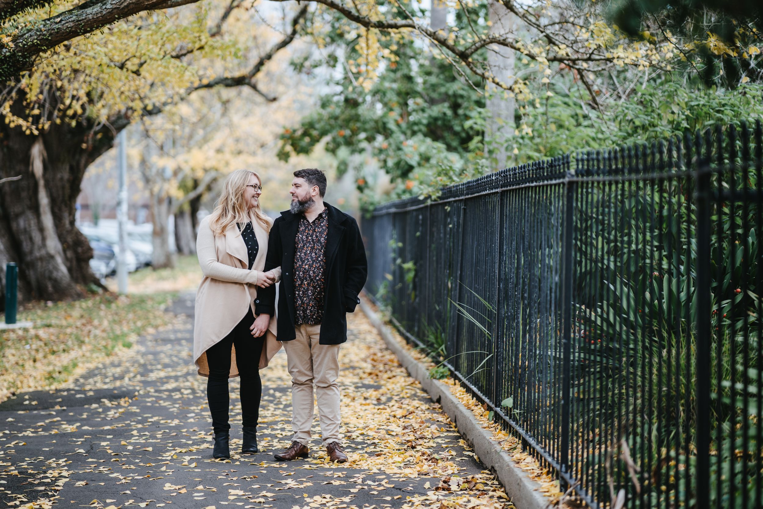 Couple walking next to Albert Park in Auckland CBD during Autumn
