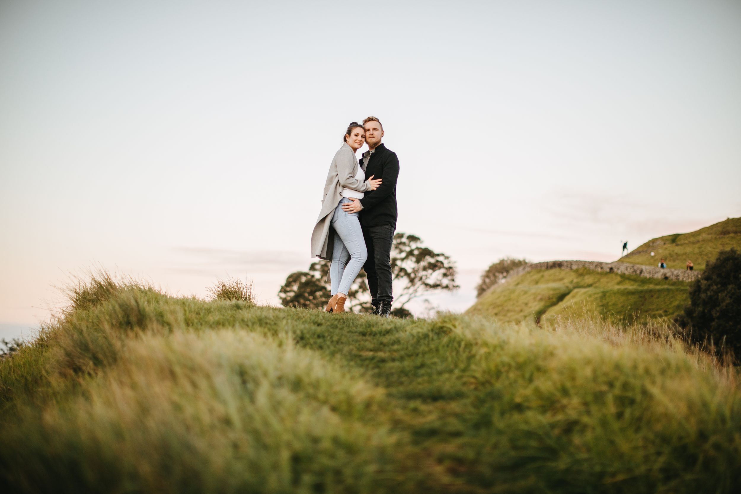 Couple posing on top of One Tree Hill Green Lane Auckland during sunset